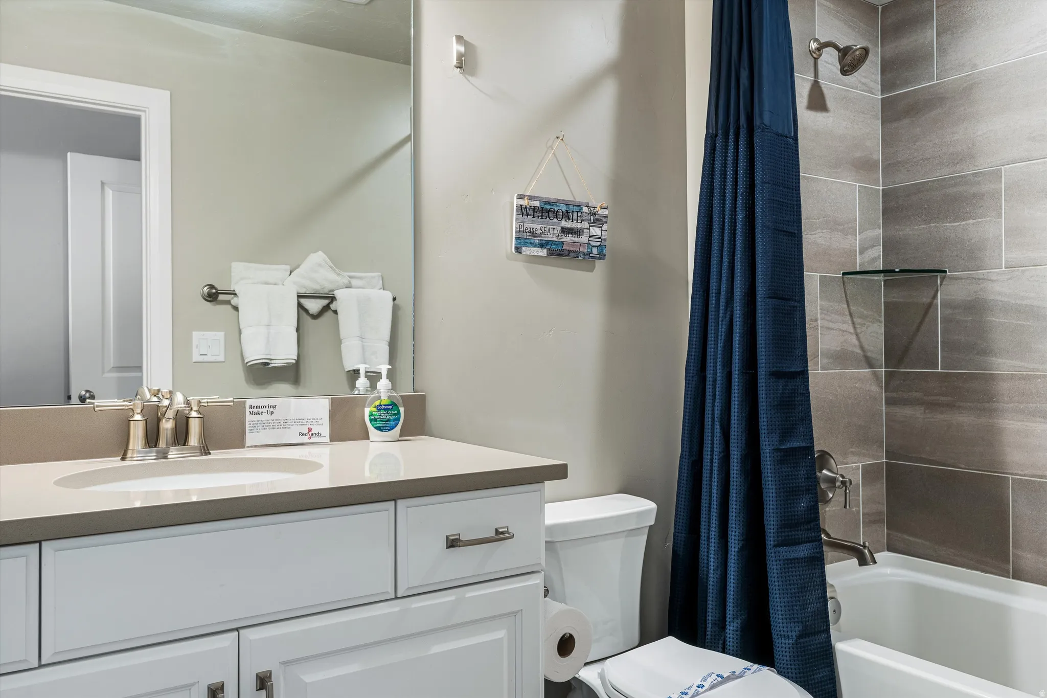 Vanity with an integrated sink, brushed nickel faucet, and white cabinetry with drawer storage