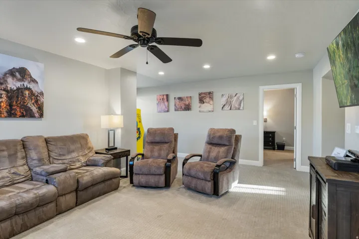 Recessed lighting, ceiling fan, neutral wall tones, carpeted flooring, and a doorway