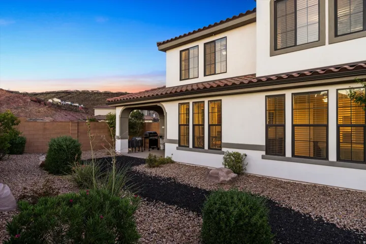 Stucco exterior with a tile roof, an arched covered patio, and multi-pane windows