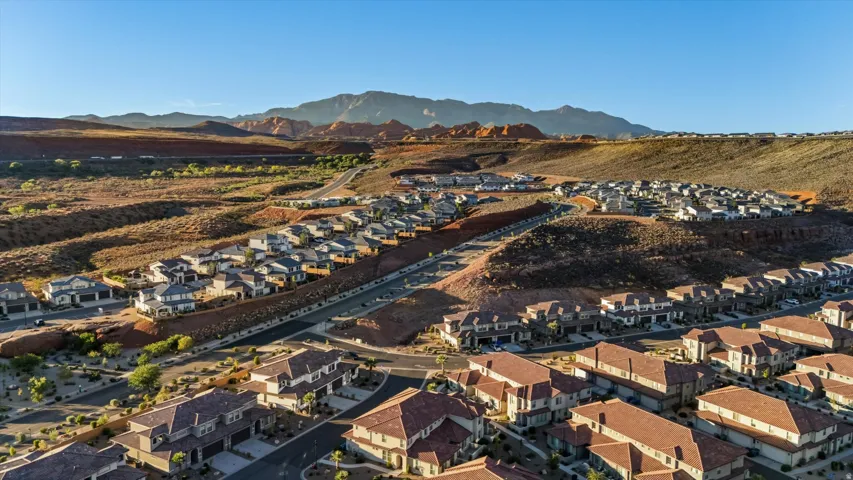 Residential development with varying rooflines and building materials, featuring mountain and desert terrain