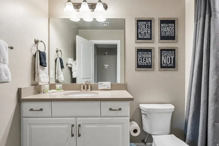 Vanity with an integrated sink, brushed nickel fixtures, a framed mirror, and a wall-mounted light fixture