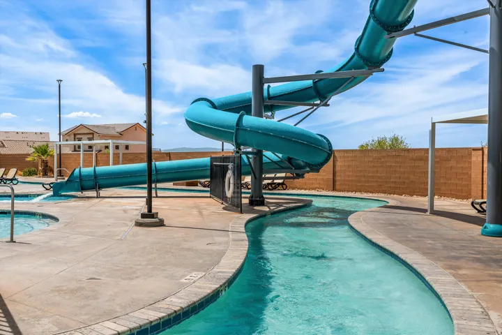 Swimming pool area featuring a curved water slide, a lazy river, and a spa