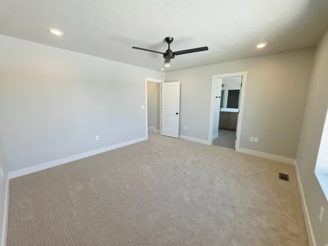 Neutral carpet flooring, recessed lighting, and a contemporary ceiling fan