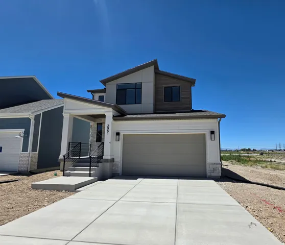 Contemporary exterior with a two-car garage, concrete driveway, and stone accents