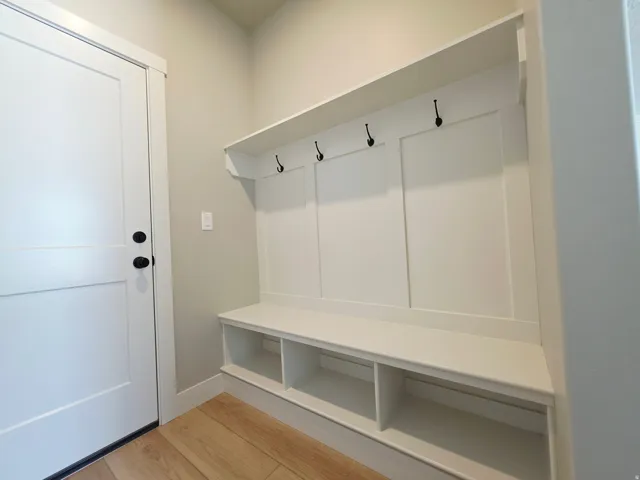 Built-in bench with integrated shelving, storage hooks, and wood-finish flooring