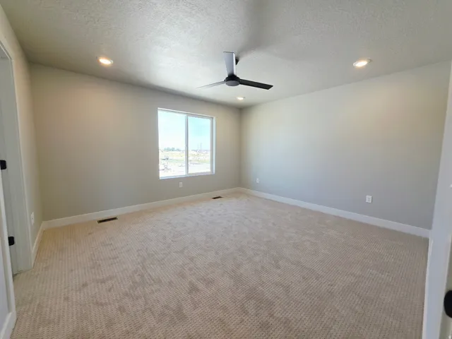 Recessed lighting, ceiling fan with black blades, single window, light-toned carpeting, and light gray wall paint