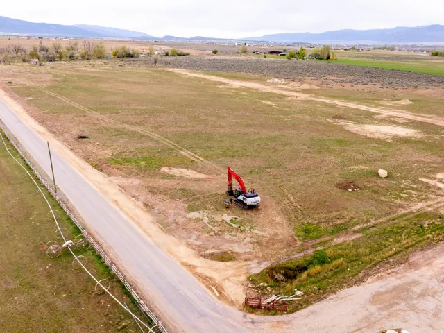 Expansive rural property featuring an unpaved road and distant mountain range