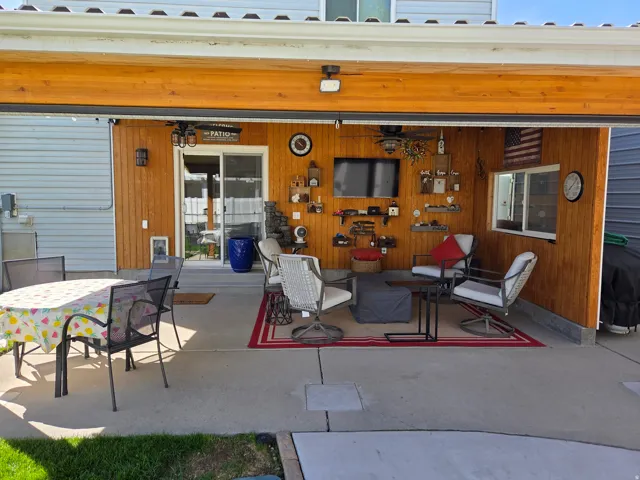 Covered patio with wood-paneled walls and a sliding glass door