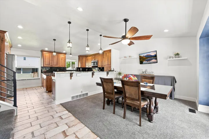 Kitchen with wood-finish cabinetry, stainless steel appliances, and pendant lighting