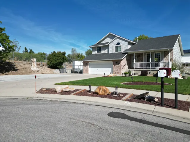 Two-story residence featuring a brick facade, covered porch, and an attached two-car garage