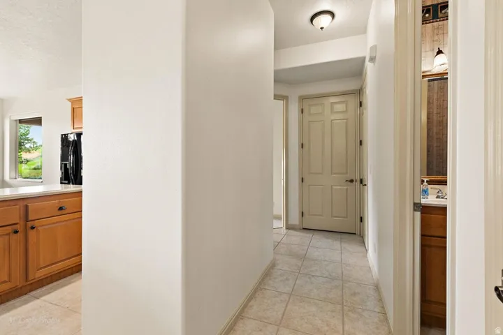 Hallway featuring tile flooring, a panel door, and an overhead flush-mount light fixture