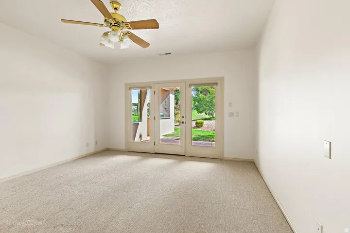 Recessed lighting fixture with a ceiling fan, carpet flooring, and glass-paned double doors
