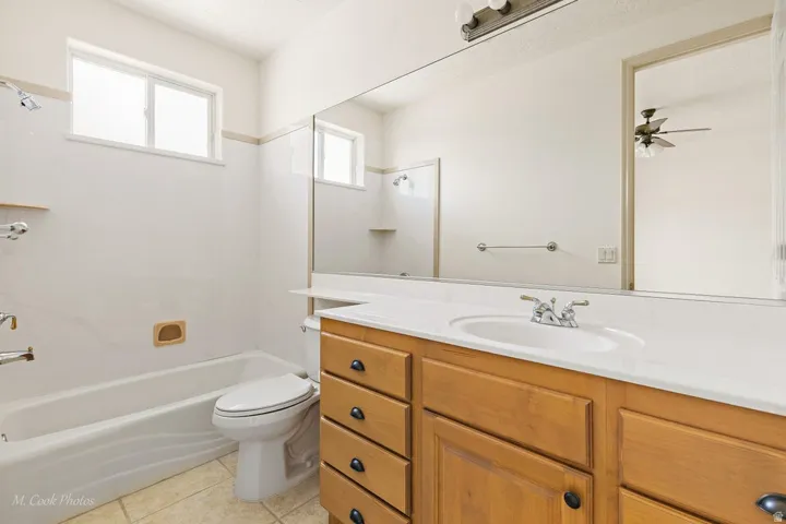 Wood-finish vanity with a white countertop and integrated sink