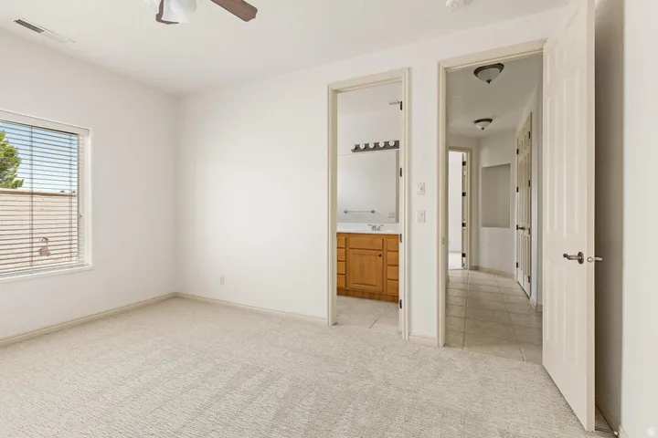 Bedroom featuring neutral carpeting, a ceiling fan, and a window with blinds