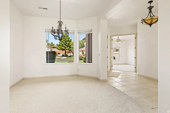 Recessed lighting, chandelier, ceiling fan, arched doorway, and tile flooring