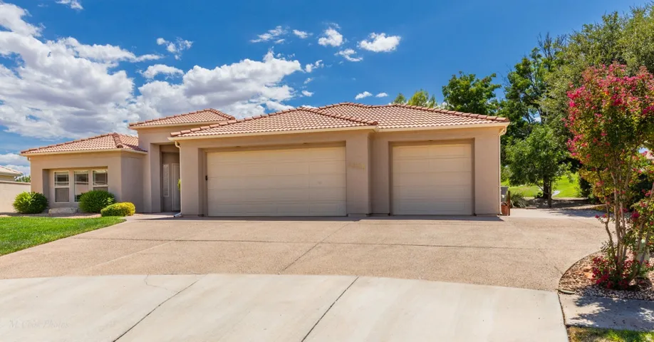 Stucco exterior with a tile roof, two-car garage, and a concrete driveway