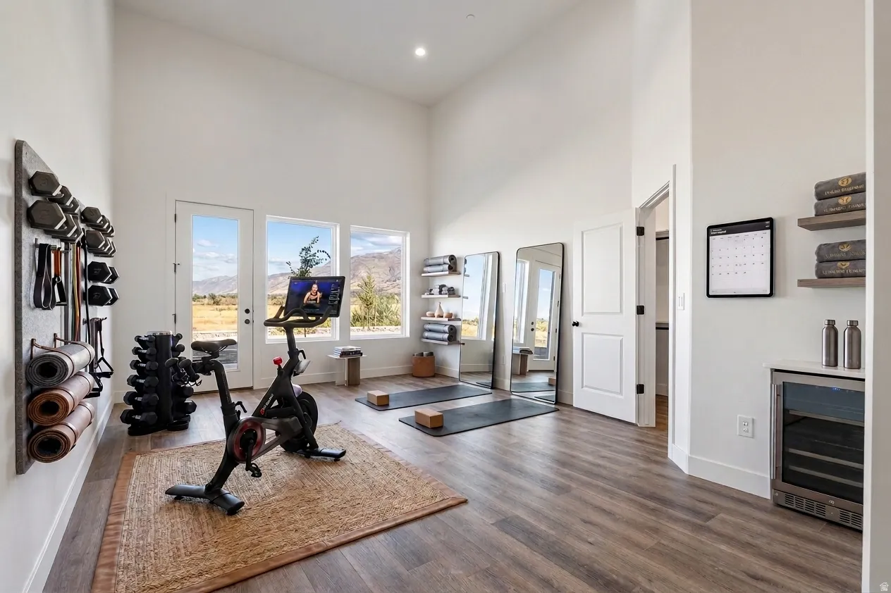 Vaulted ceilings, wood-finish flooring, white walls, built-in shelving, and a beverage cooler