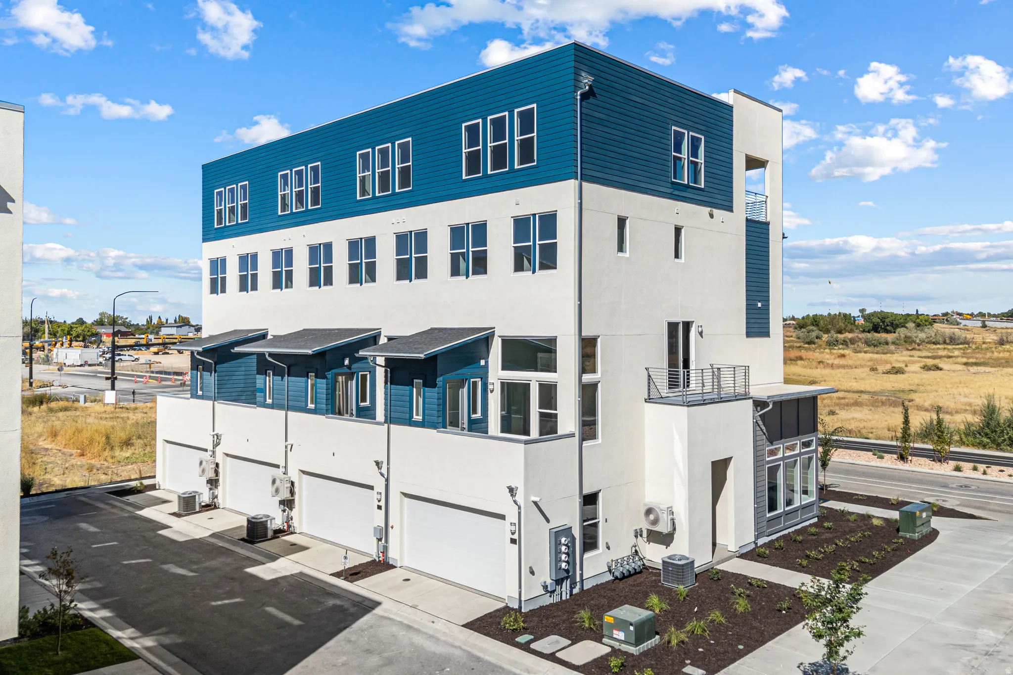 Contemporary multi-story facade featuring blue siding accents and numerous window openings
