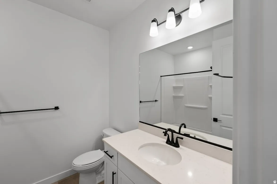 Bathroom featuring a single vanity with light-toned countertop, undermount sink, and matte black faucet