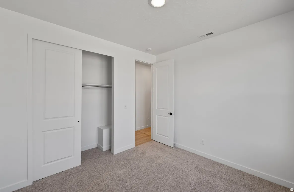Neutral-toned carpeting and white walls create a bright interior