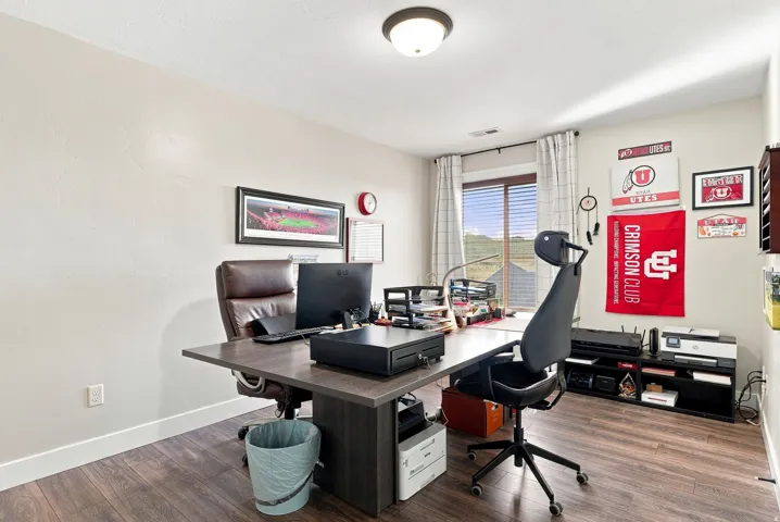 Upstairs bedroom #5 or office. Recessed lighting, wood-finish flooring, and a window with blinds and drapes