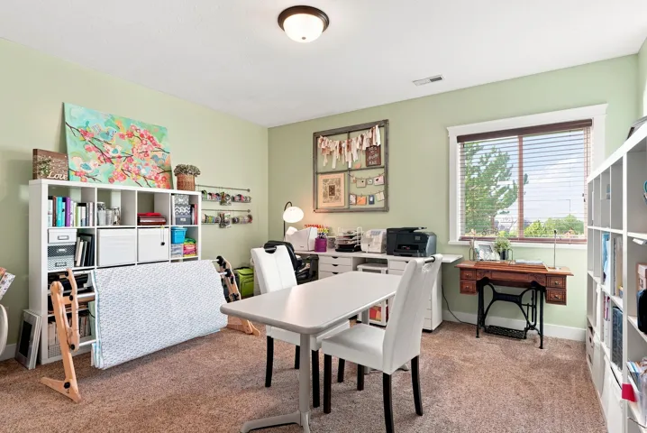 Basement bedroom #7. Recessed lighting, large window with blinds, light green wall color, built-in shelving, and neutral carpeting