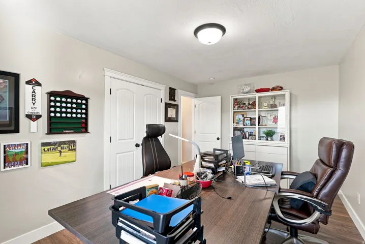 Upstairs bedroom #5 or office. Recessed lighting, wood-finish flooring, white trim, and a built-in display cabinet