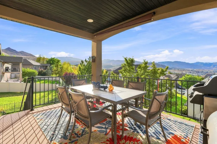 Covered outdoor deck with composite decking, black metal railing, and recessed lighting