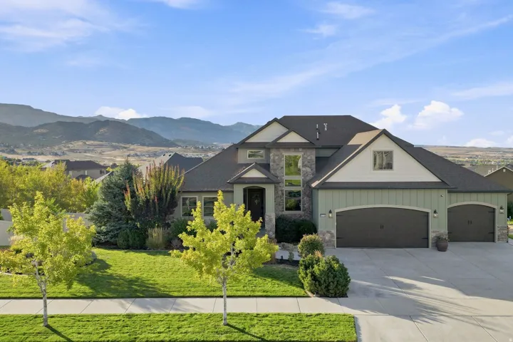 Contemporary residence featuring stone and siding exterior accents, a multi-car garage, and a concrete driveway
