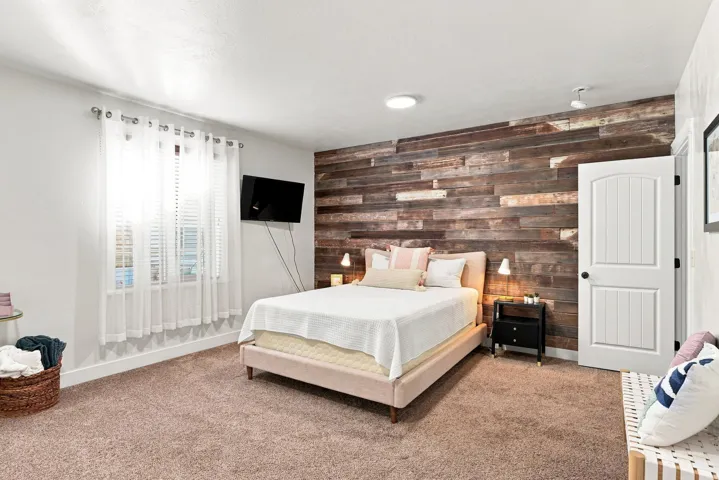 Basement bedroom #6. Accent wall featuring wood-finish paneling