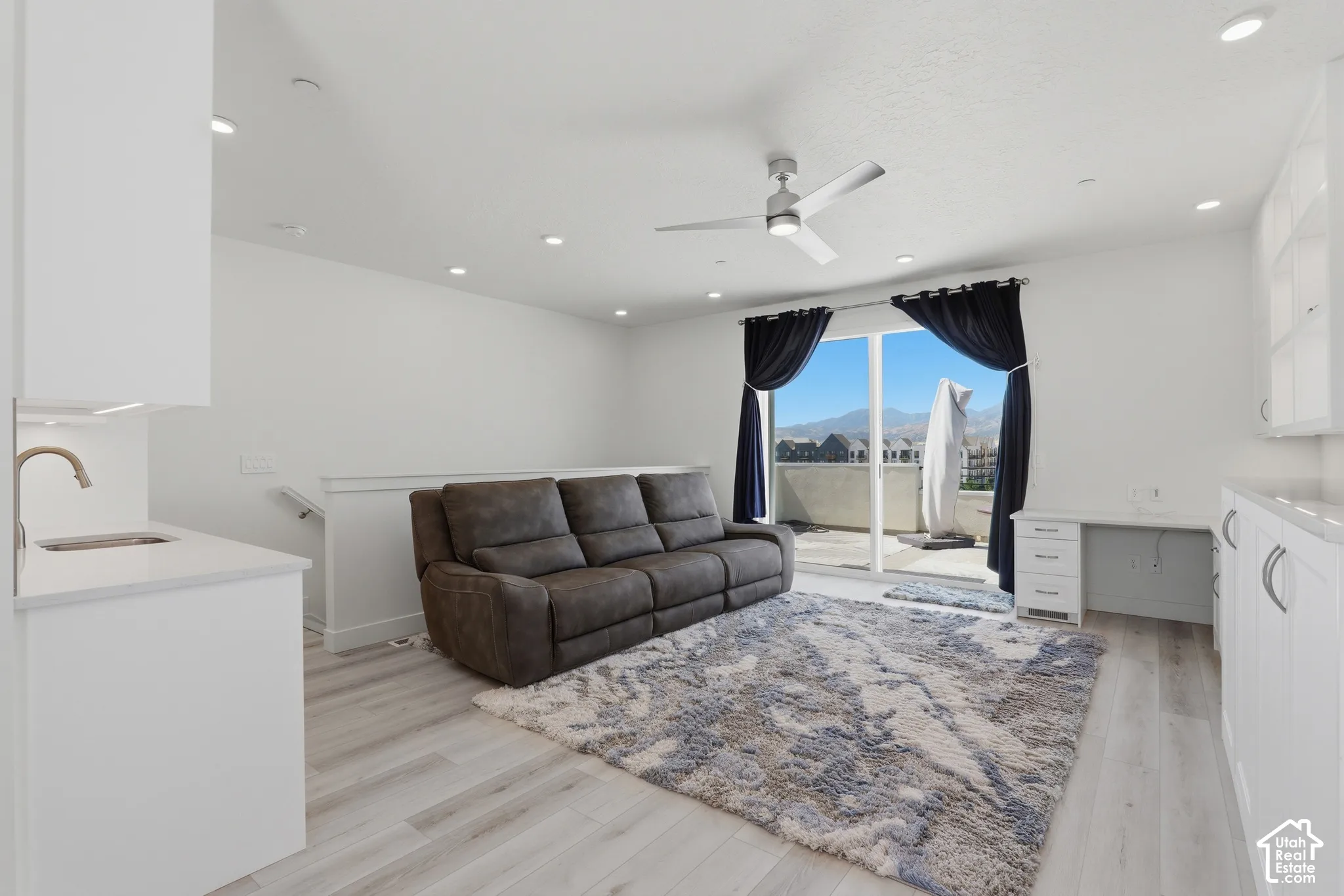 White cabinetry and light-toned wood-finish flooring