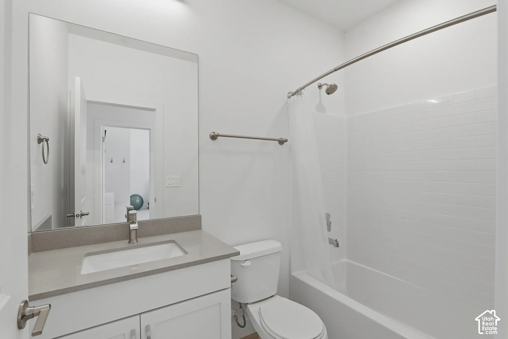 White vanity with brushed nickel hardware, light-toned countertop, and undermount sink