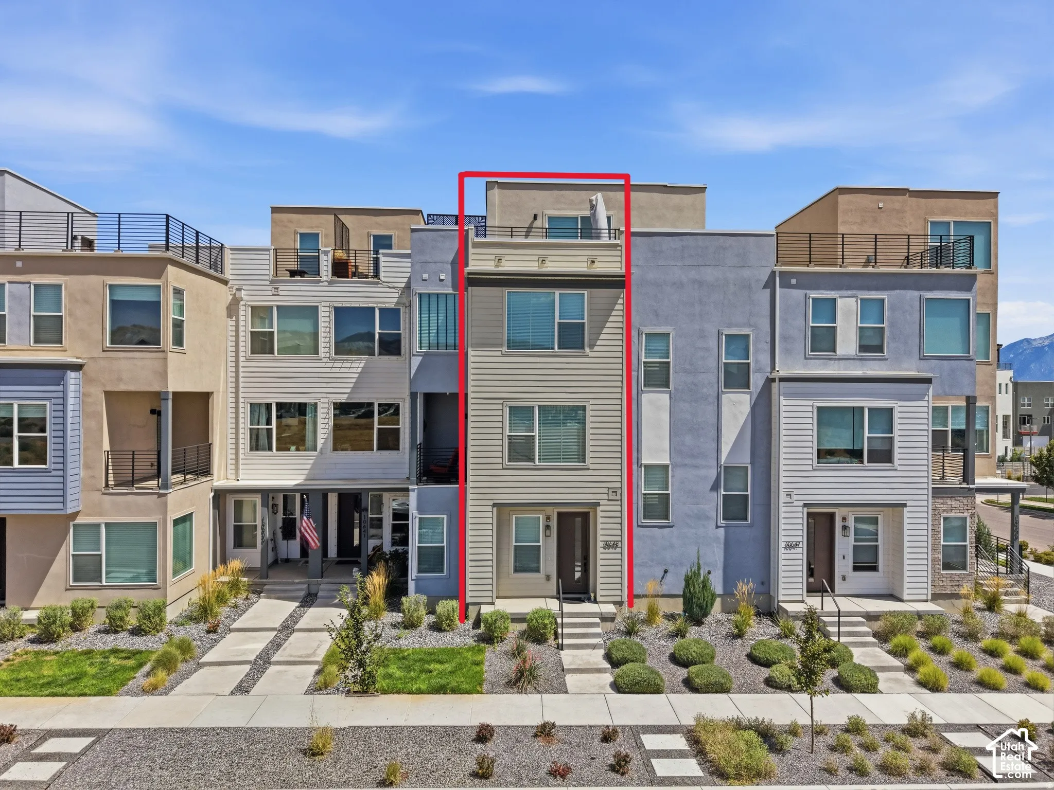 Modern exterior with vertical siding, multiple windows, and a rooftop deck