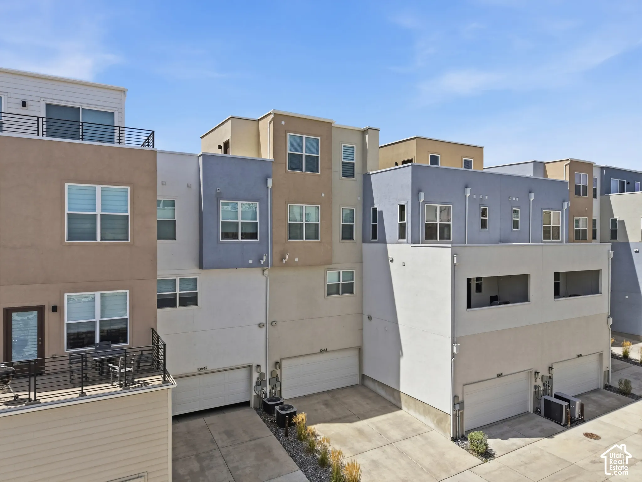 Contemporary multi-level exterior with multiple window openings, private balcony, and integrated garage access