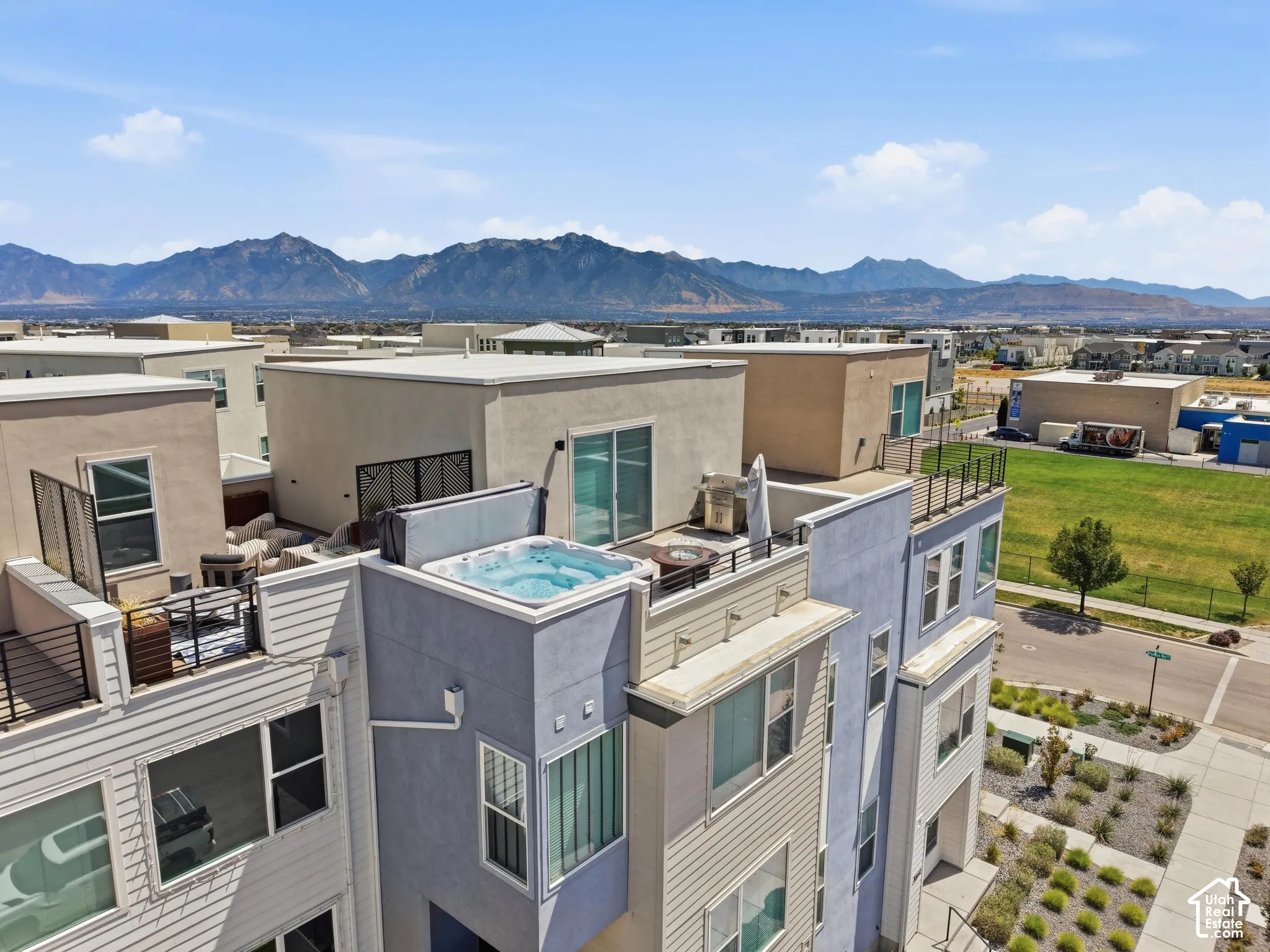 Rooftop terrace featuring a built-in hot tub, privacy screening, and expansive mountain scenery