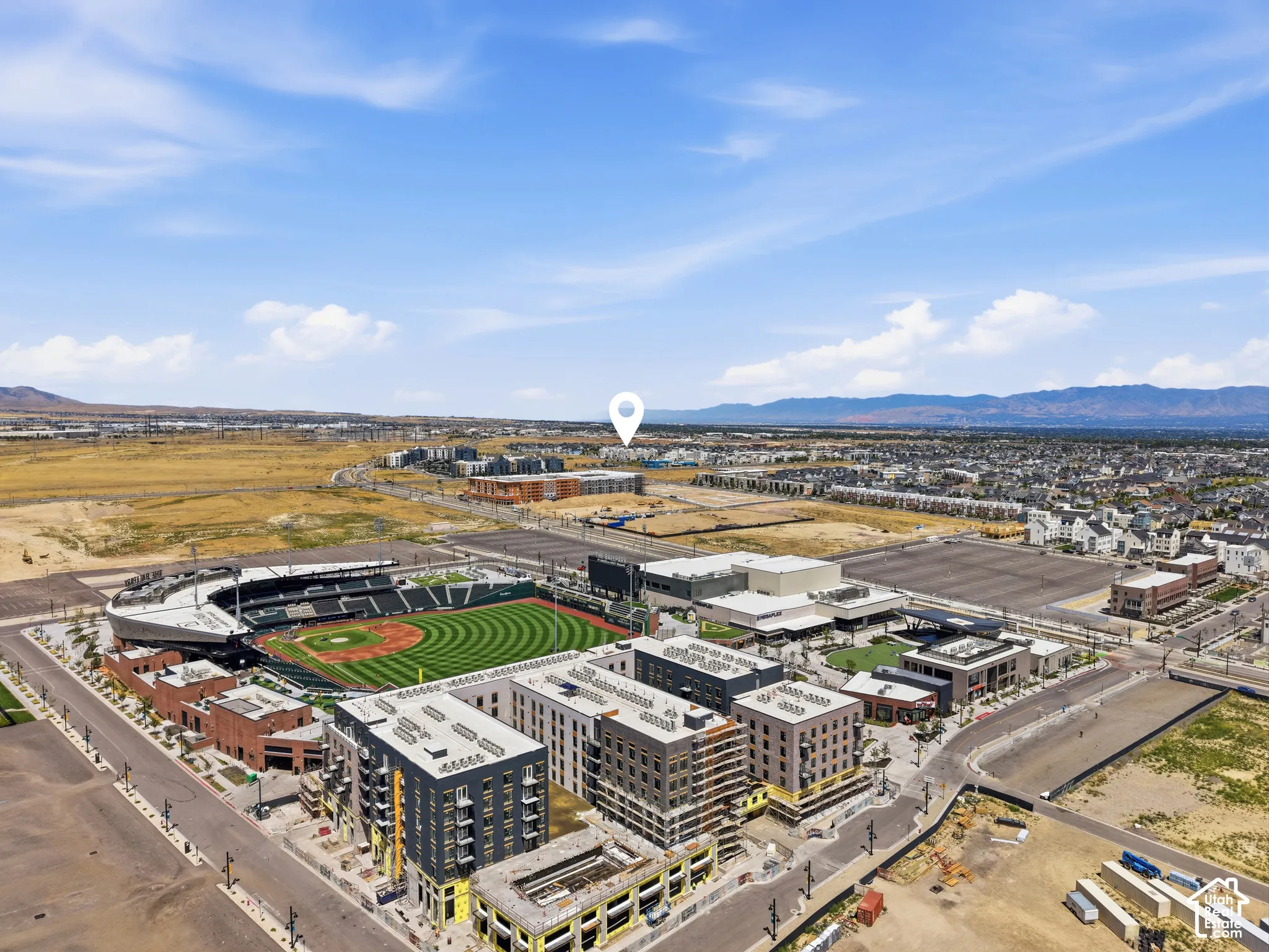 Aerial perspective featuring a stadium, multi-story buildings, and expansive open land