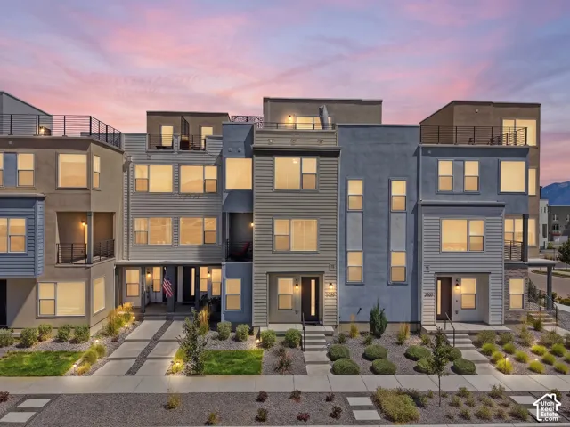 Contemporary multi-story facades with varied siding, rooftop patios with metal railings, and integrated exterior lighting