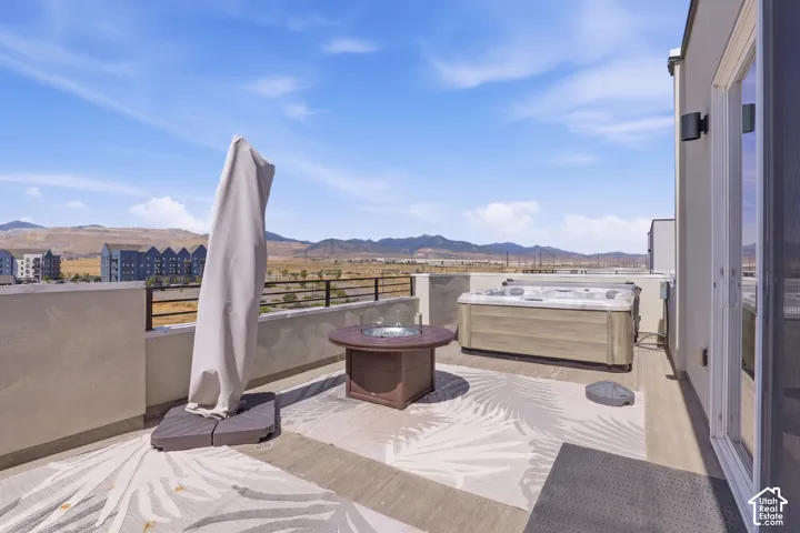 Rooftop terrace with a built-in hot tub, fire pit, and durable railing
