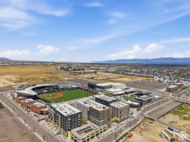 Baseball stadium, multi-story residential buildings, commercial structures, mountain backdrop, and expansive open terrain