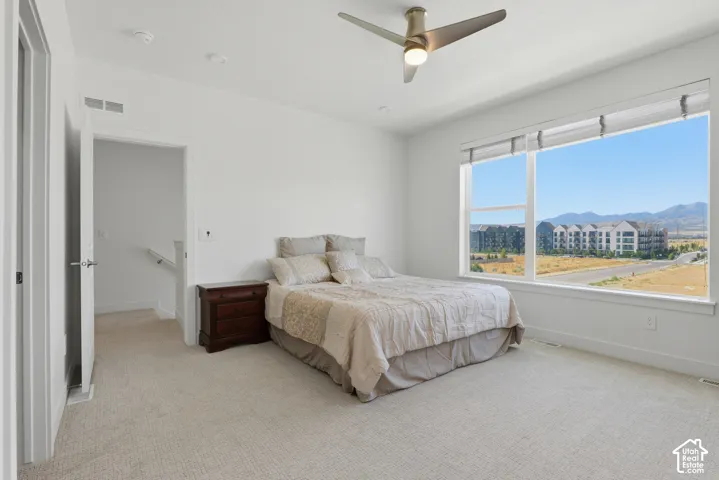 Recessed lighting, ceiling fan, carpeting, large windows, and a mountain backdrop