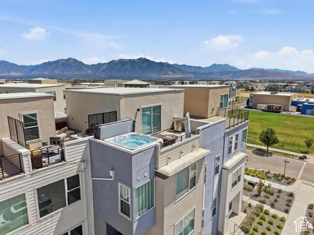 Rooftop terrace featuring a built-in hot tub, privacy screening, and expansive mountain scenery
