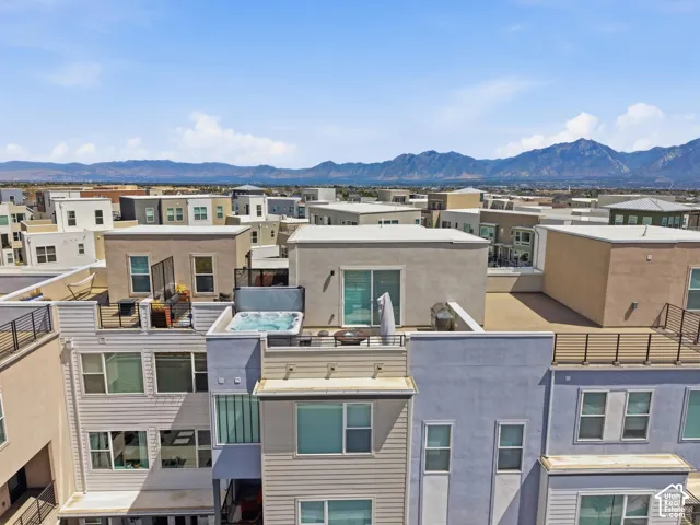 Rooftop patio with a built-in hot tub, mountain backdrop, and multiple levels of outdoor space