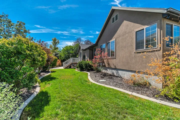 Stucco exterior with multiple windows, concrete foundation, and a wooden deck with railing