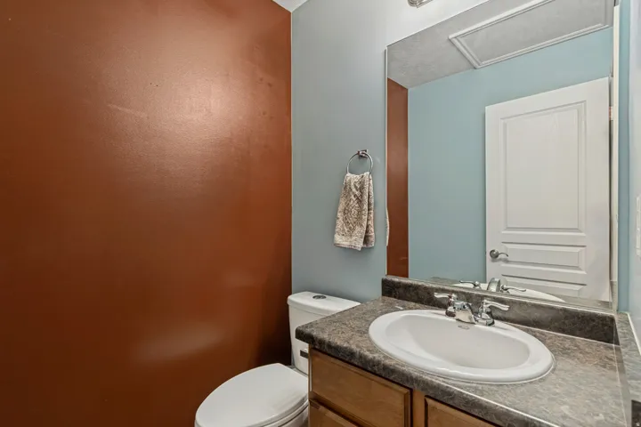 Vanity with integrated sink, chrome faucet, and dark-toned countertop