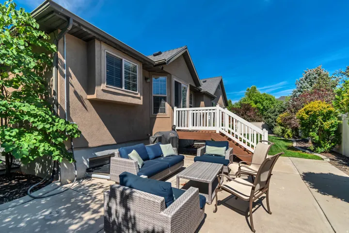 Patio with concrete surfacing, adjacent to a multi-level deck featuring white railings