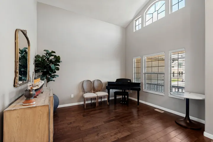 Vaulted ceilings with architectural windows, wood-finish flooring, and white trim