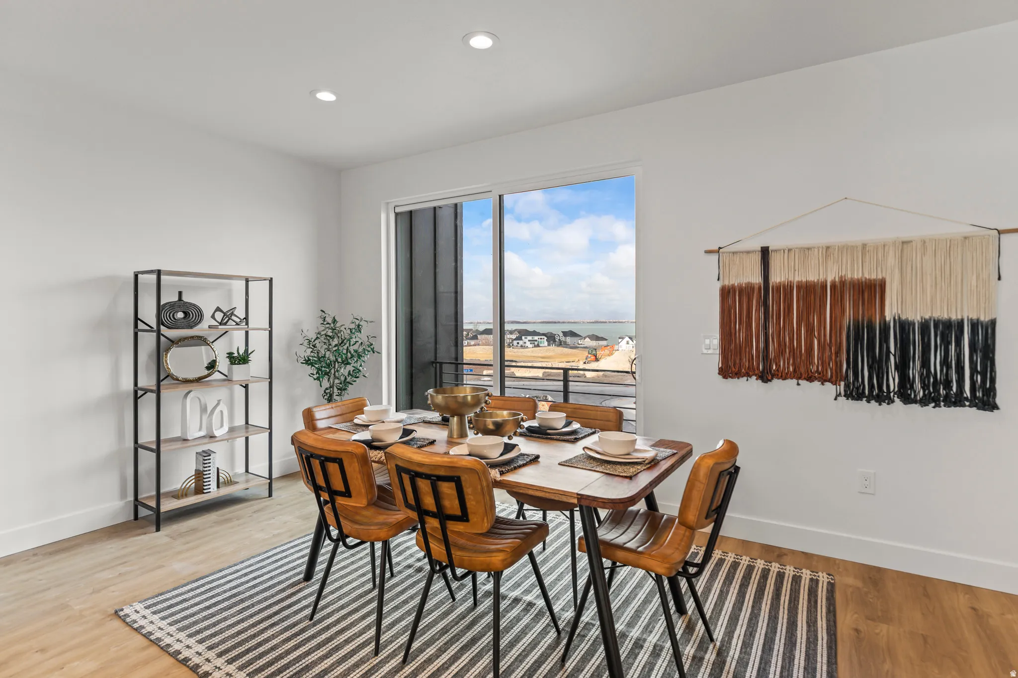 Recessed lighting, wood-finish flooring, sliding glass door, white walls, and a built-in shelf