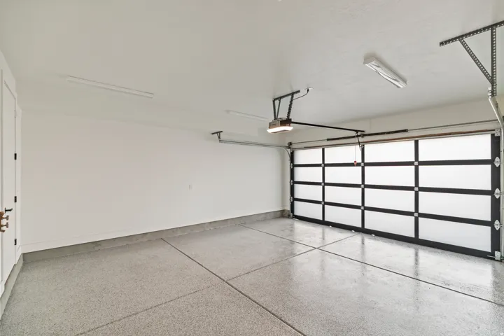 Modern garage door with frosted panels, automatic opener, and epoxy flooring