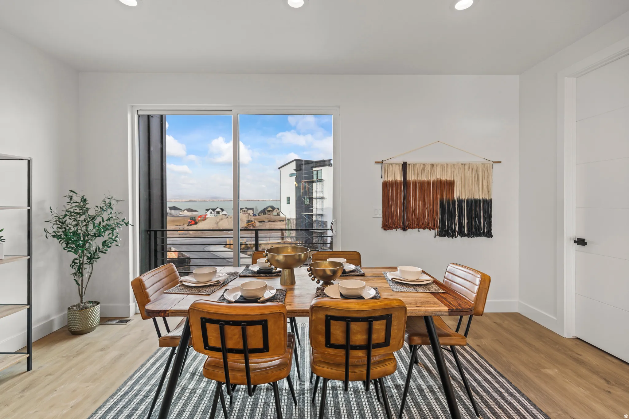 Recessed lighting, wood-finish flooring, white walls, and a sliding glass door to an outdoor space