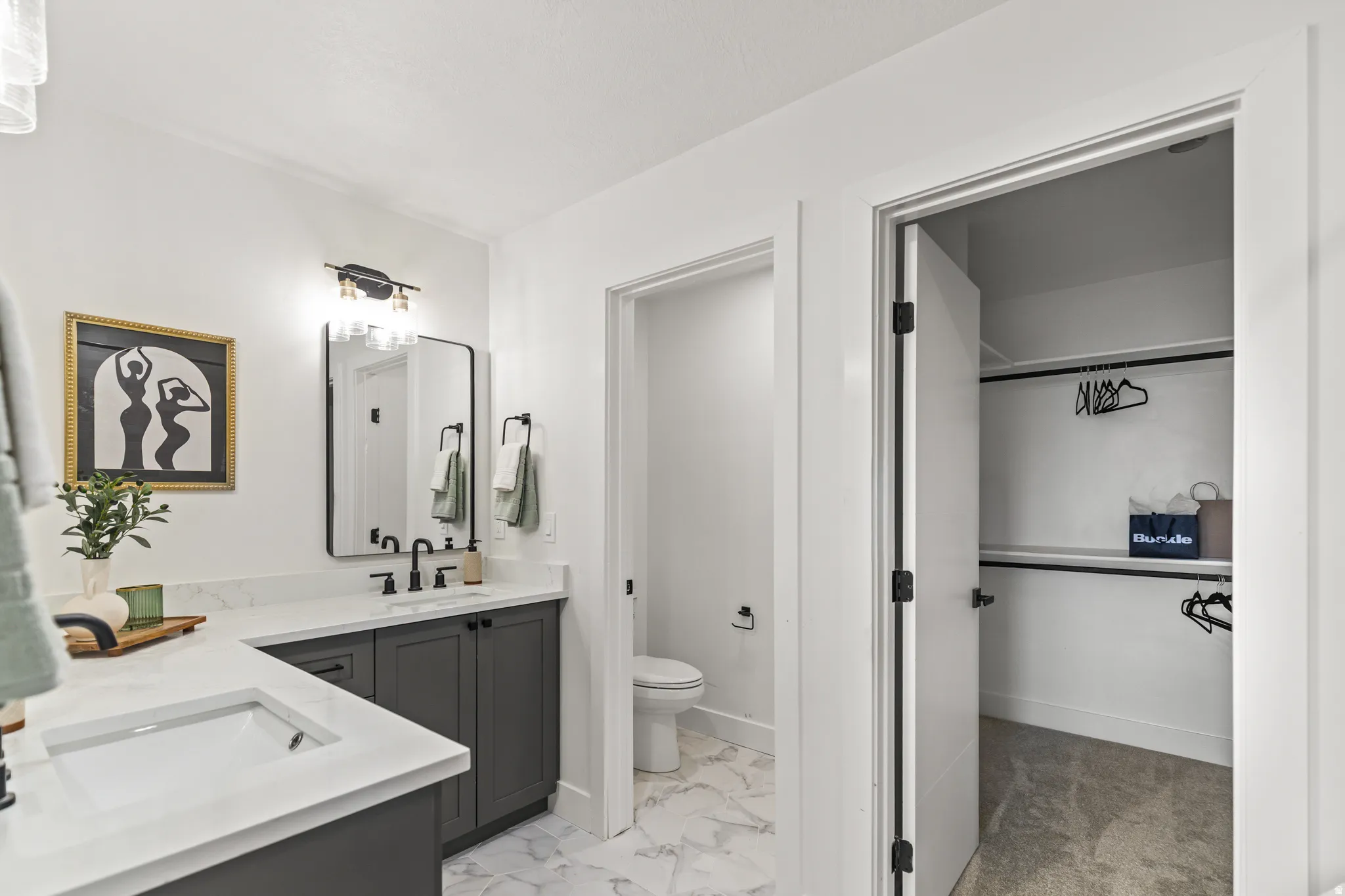 Double vanity with white countertops, dark gray cabinetry, and black hardware